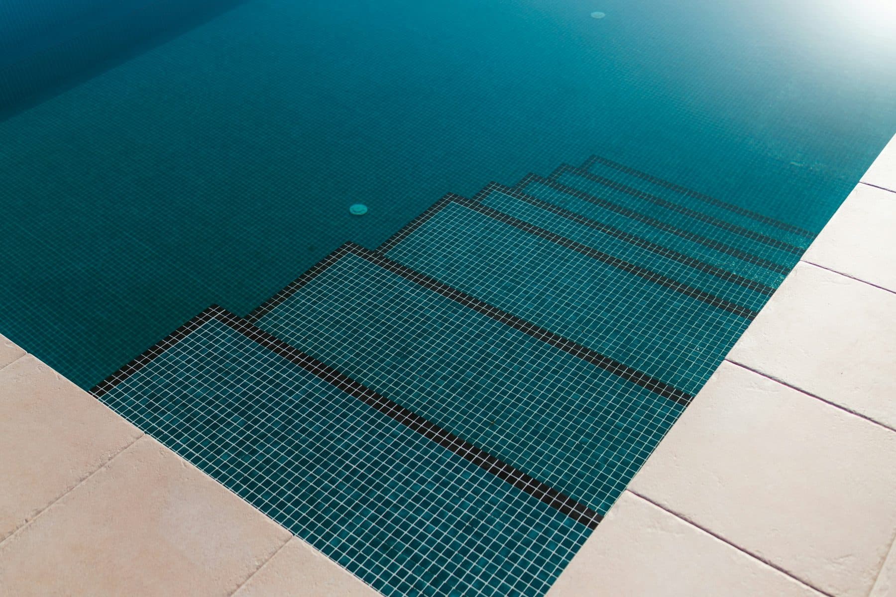 The eleven-metre pool set level with the andesite terrace, water still at dusk.