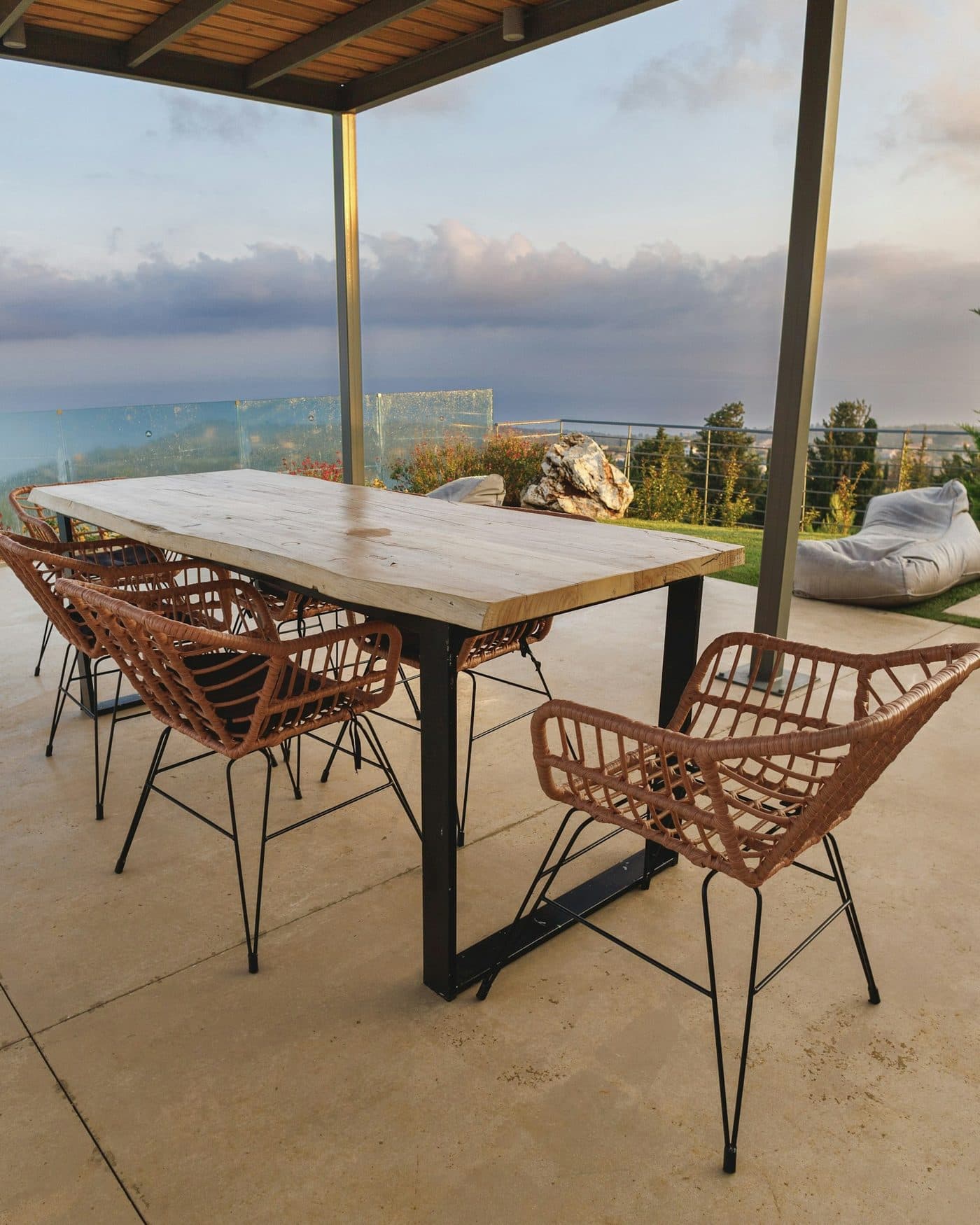 The long teak table set for dinner on the covered terrace.