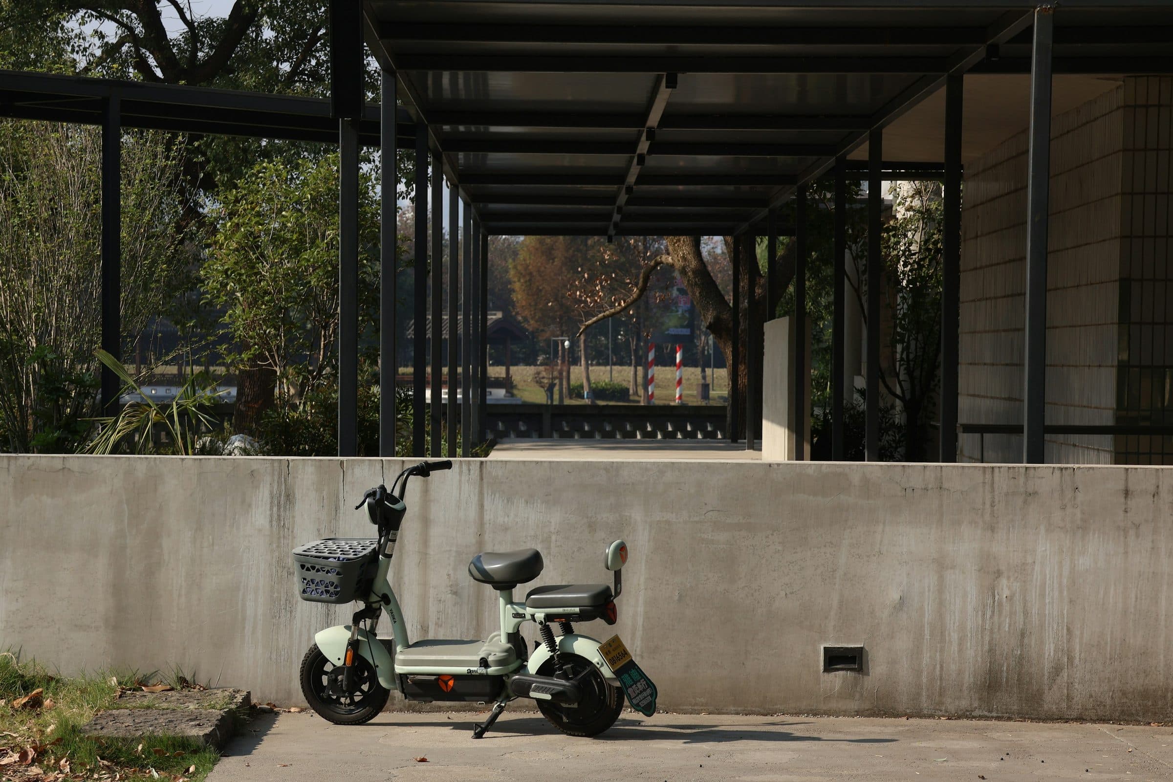 The lane outside the villa, a scooter parked against a rendered wall.