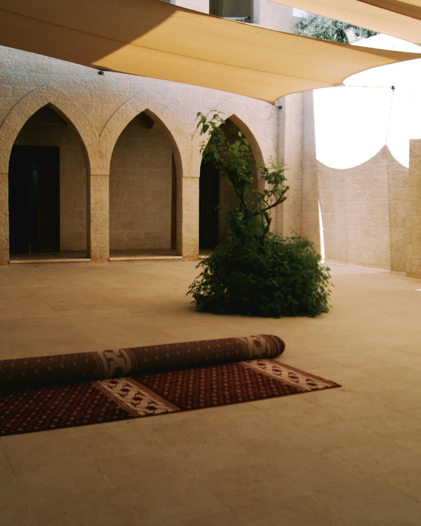 A mat laid out on the stone terrace in the shade of the eaves.