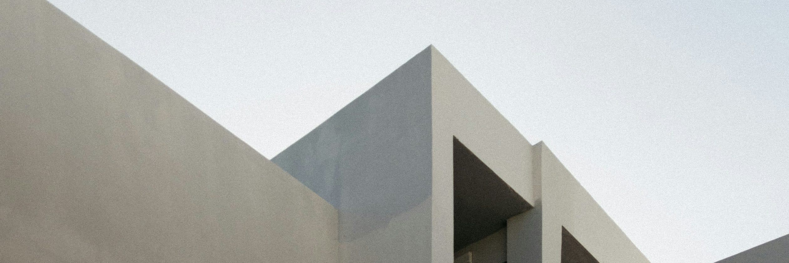 The approach to the villa: a concrete screen wall opening onto the entry court.